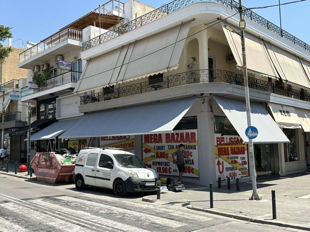 Γωνιακό κτίριο με λευκές τέντες σε κατάστημα και μπαλκόνια, Pergotenta