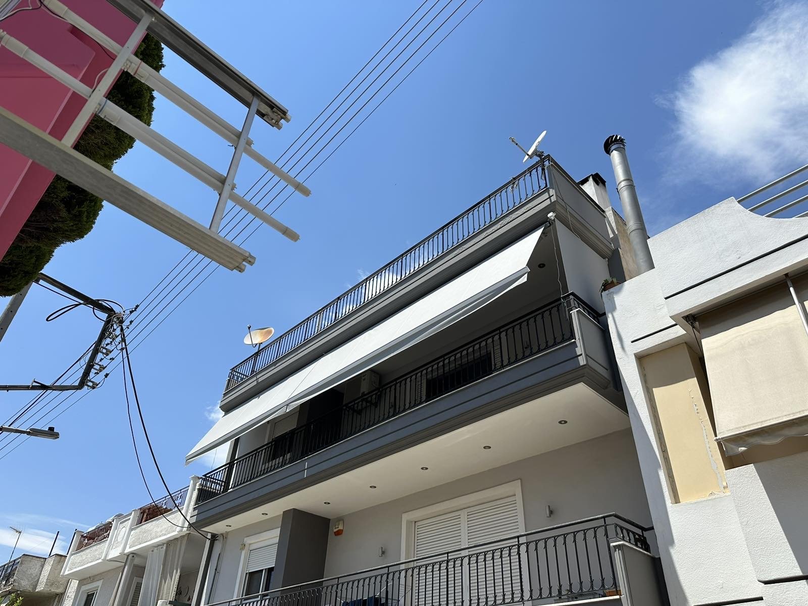 Πολυκατοικία με λευκές τέντες με βραχίονες, Pergotenta