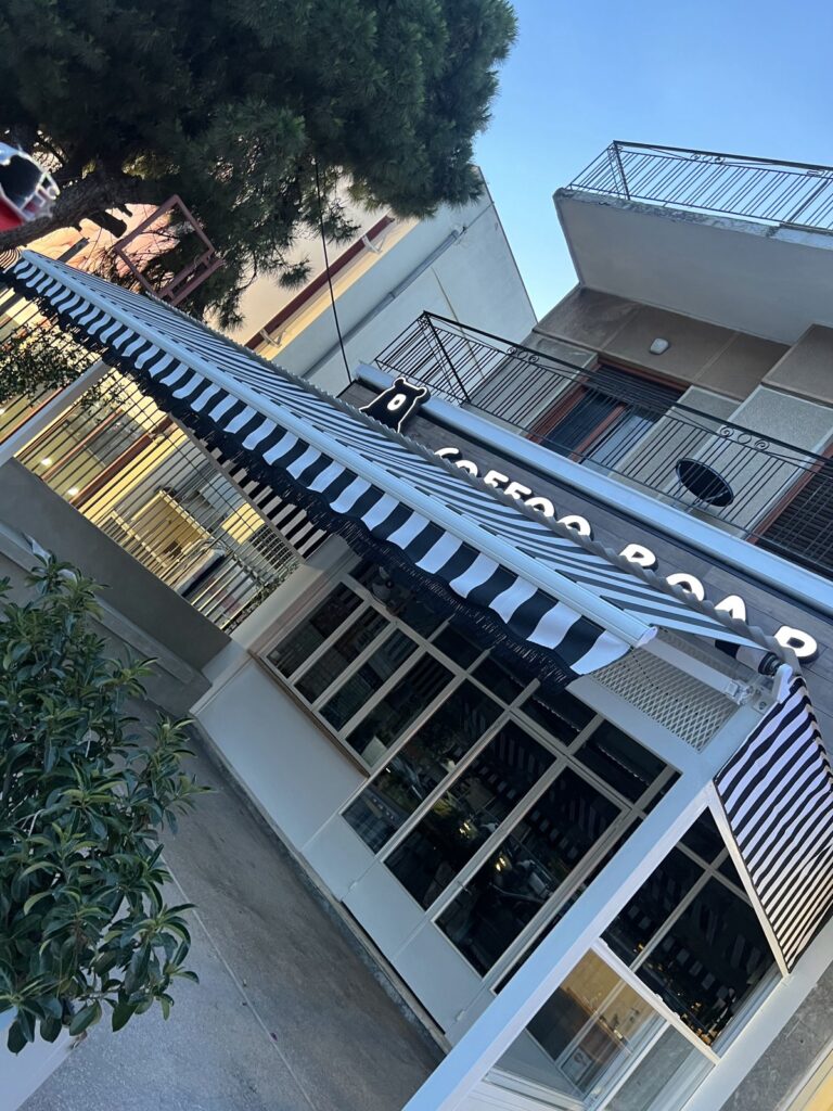 Ασπρόμαυρη ριγέ τέντα με βραχίονες σε κατάστημα, Pergotenta