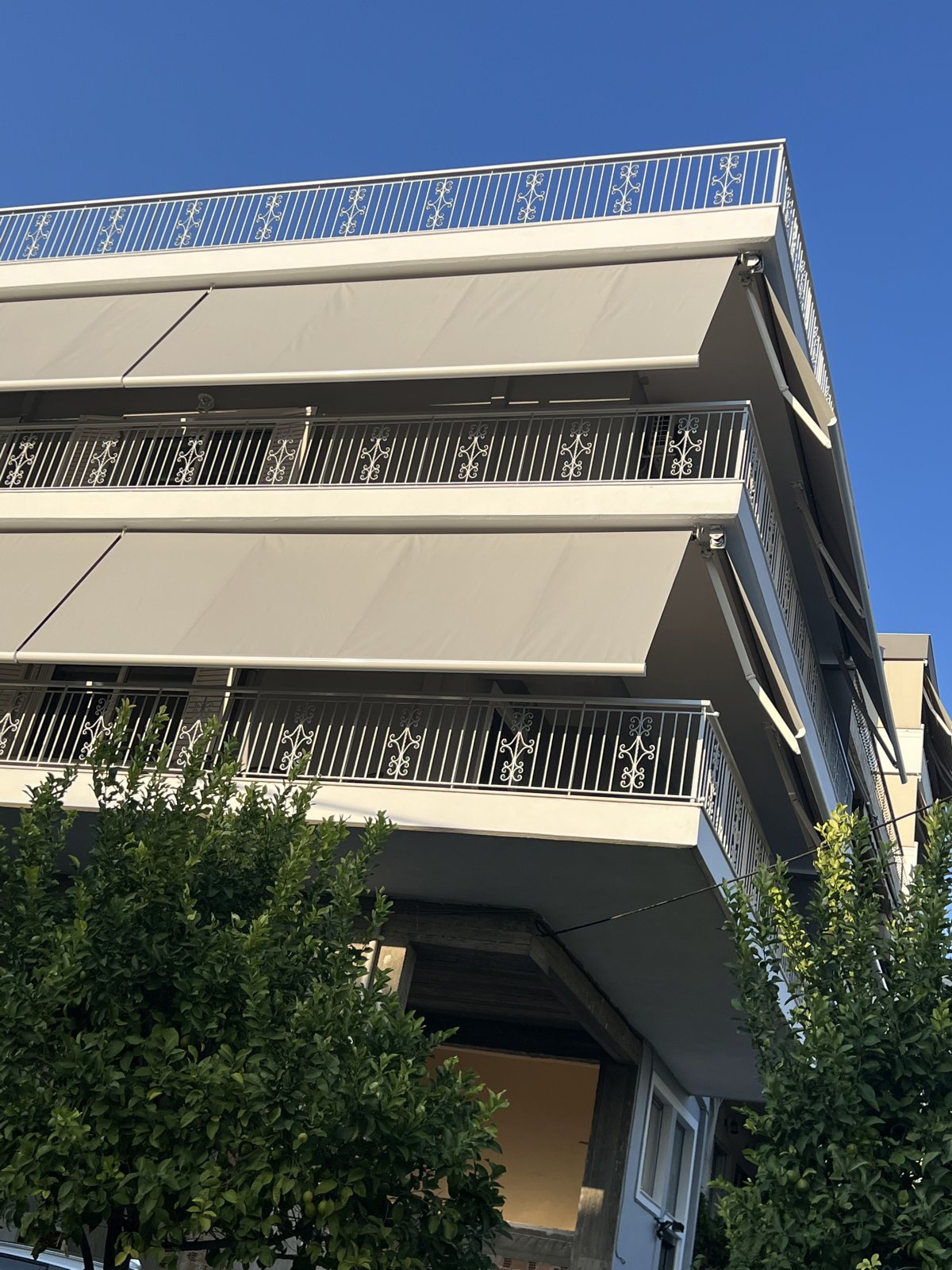 Μπεζ τέντες με βραχίονες σε μπαλκόνια πολυκατοικίας, εγκατάσταση Pergotenta