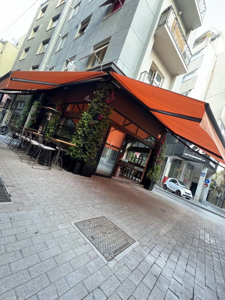 Κεραμιδί τέντες με βραχίονες σε γωνιακό καφέ μπαρ, Pergotenta